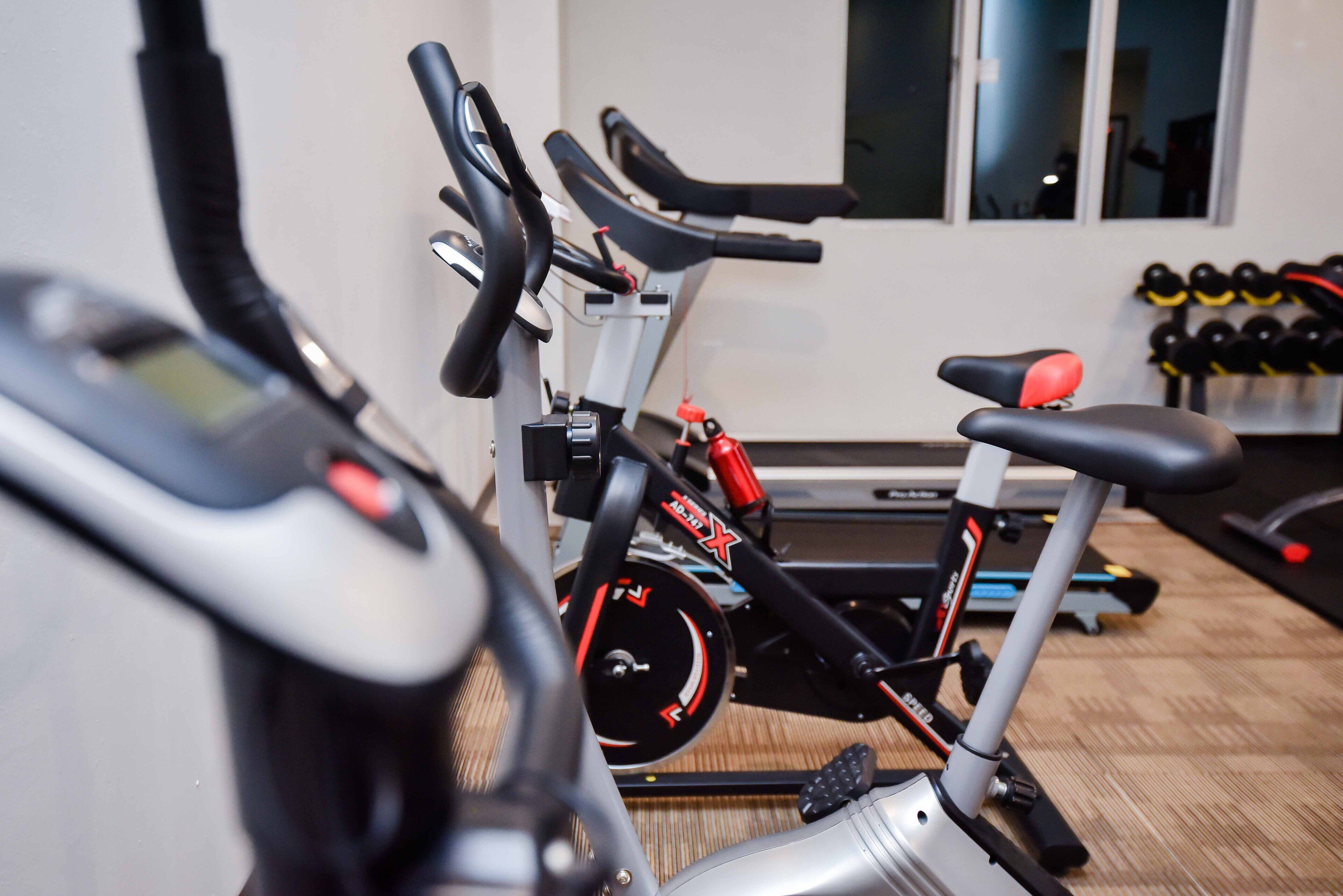 A gym with stationary bikes and dumbbells.