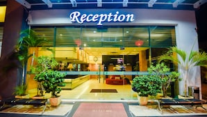 Une réception d’hôtel avec une entrée bien dégagée, un paillasson et des plantes en pot.