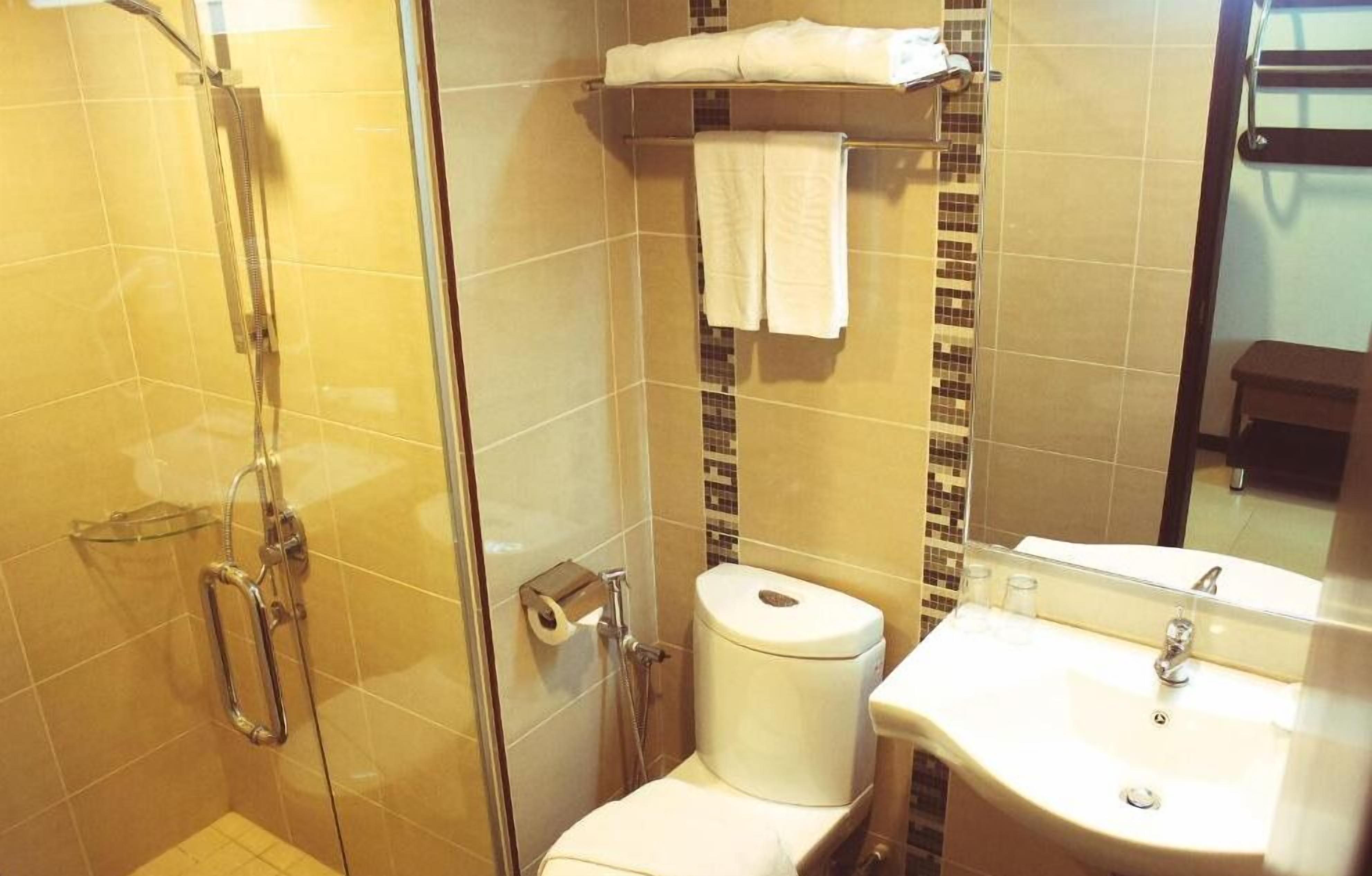 Une salle de bain avec une douche à parois de verre, des toilettes et un lavabo avec un miroir.
