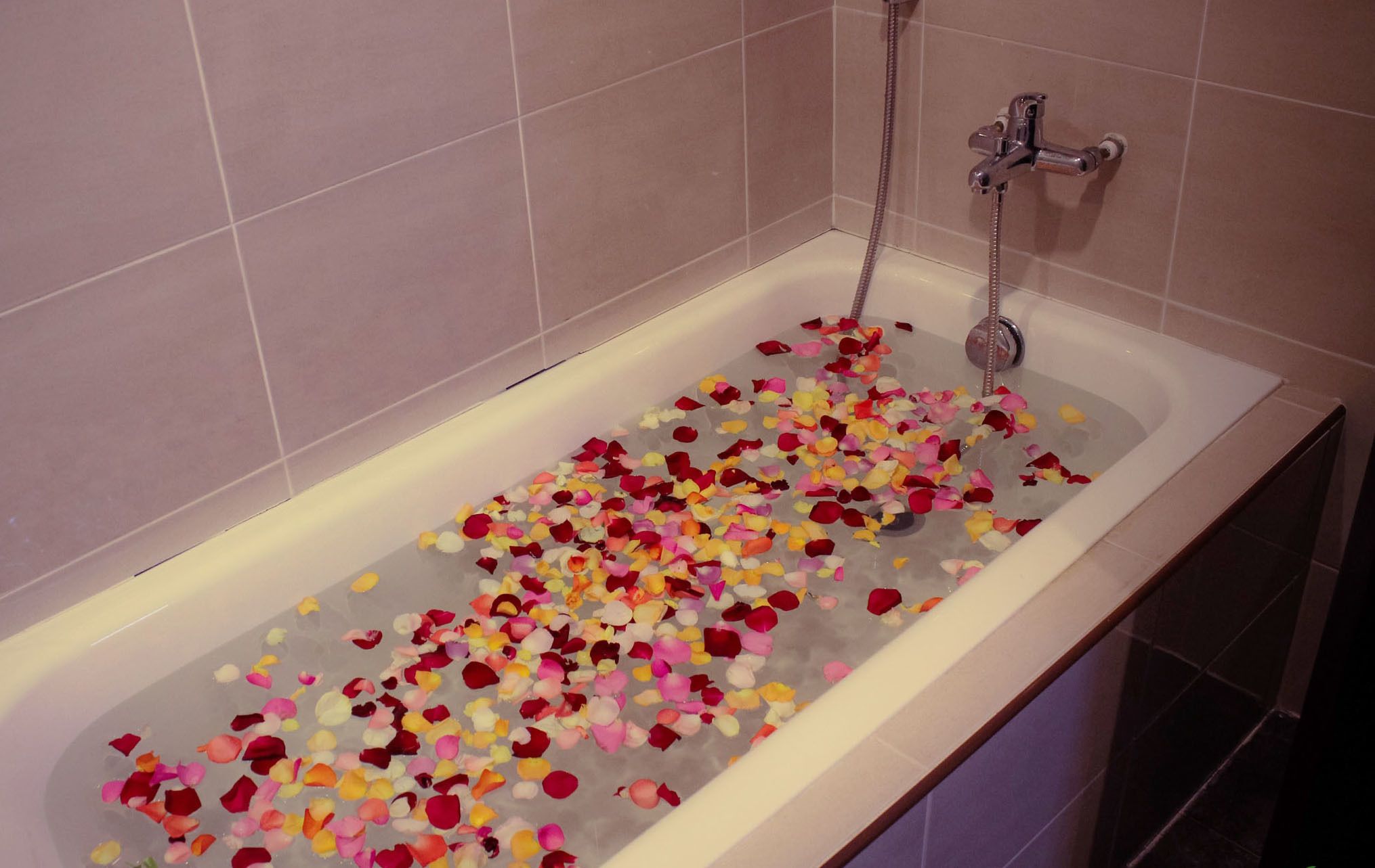A bathtub filled with rose petals.