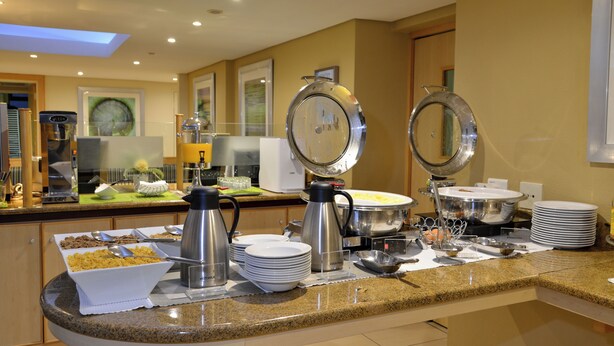 Un buffet proposant une variété de plats, des plateaux de service et un coin café.