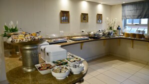 A buffet with various food items and a coffee station.