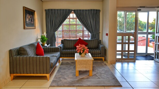 A living room with two sofas, a coffee table, and a window with curtains.