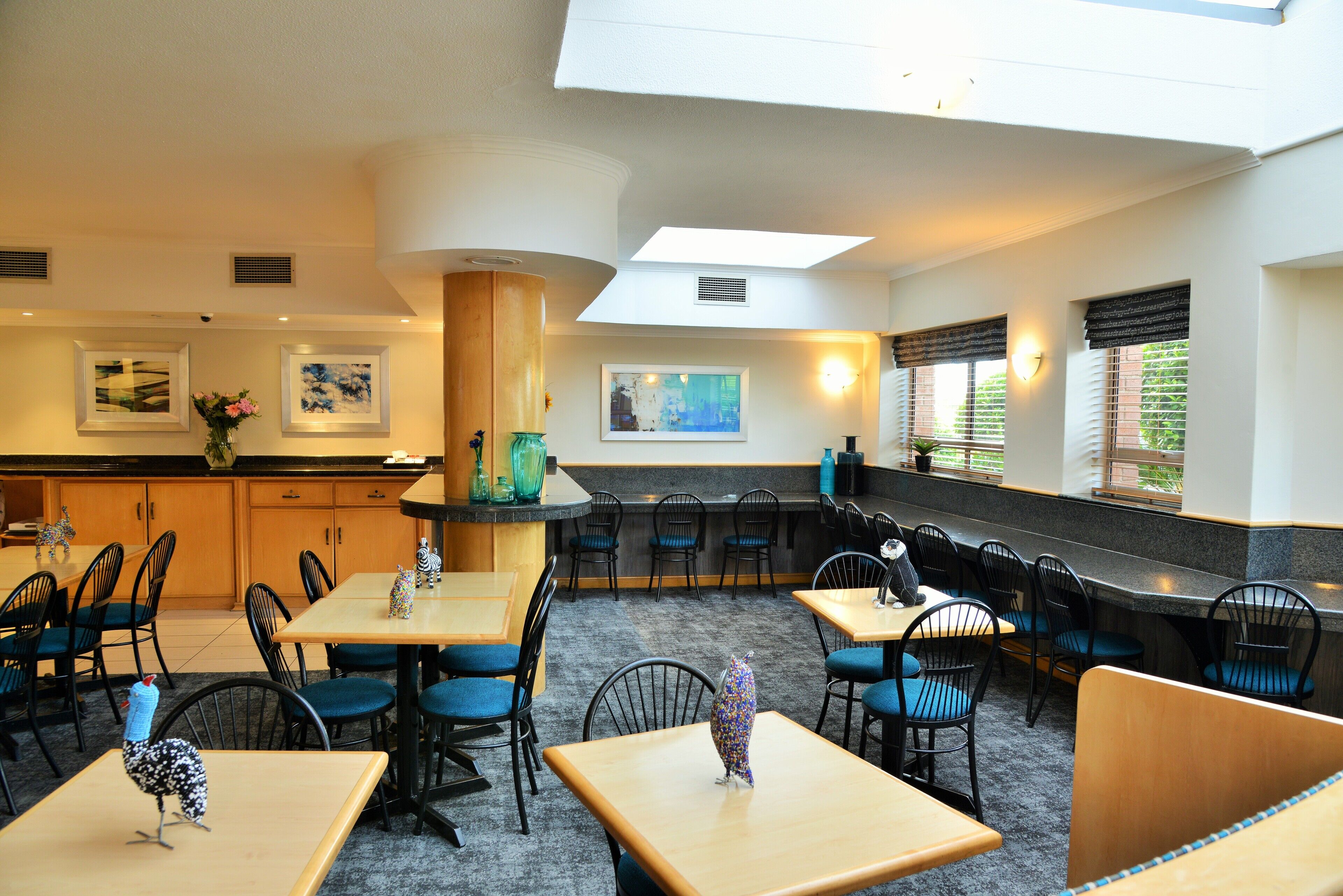 A restaurant with a high ceiling, a bar area, and multiple seating options including tables and booths.
