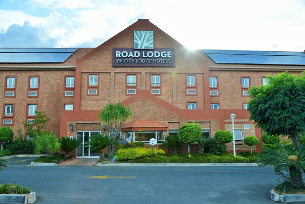 A hotel with a sign reading "Road Lodge by City Lodge Hotels," featuring a brick facade, multiple windows, and a parking lot. - Road Lodge Randburg (Randburg)