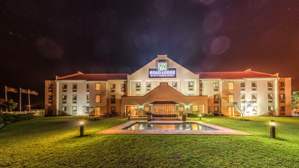 A large hotel with a central courtyard, a swimming pool, and a well-lit entrance. - Road Lodge Richards Bay (Richards Bay)