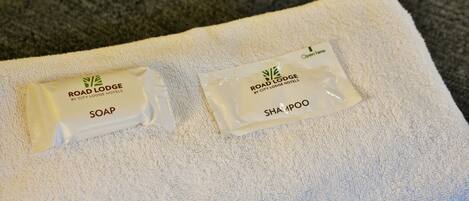 Deux trousses de toilette étiquetées « Road Lodge by City Lodge Hotels » sont posées sur une serviette blanche.