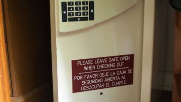 Una caja fuerte con teclado y un cartel que indica dejarla abierta al salir.