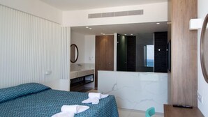 Une chambre d’hôtel moderne, équipée d’un lit, d’une salle de bain avec un miroir et offrant une vue sur l’extérieur.