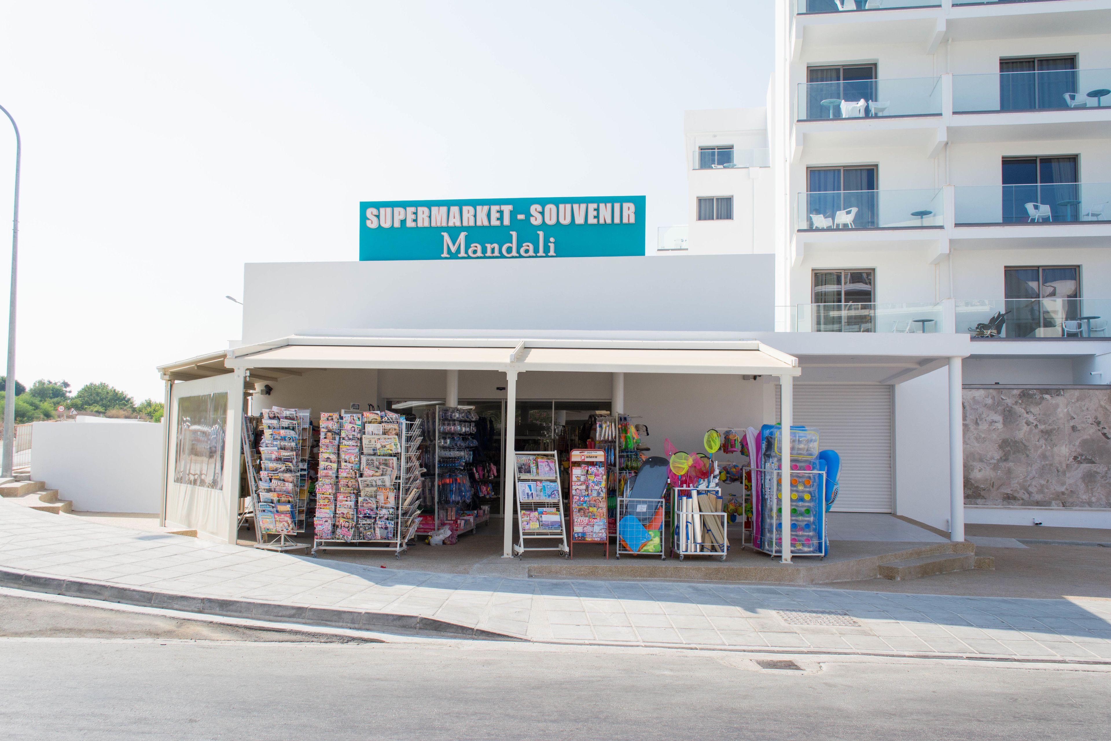 A souvenir shop named 'Supermarket-Souvenir Mandali' with various items displayed outside.