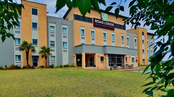 Un moderno edificio de hotel con un letrero que dice "Road Lodge by City Lodge Hotels".