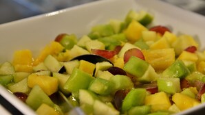 A bowl of fruit salad with various diced fruits.