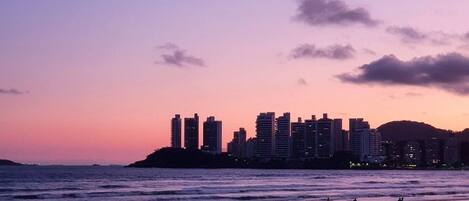 Una playa con el horizonte de una ciudad al fondo.