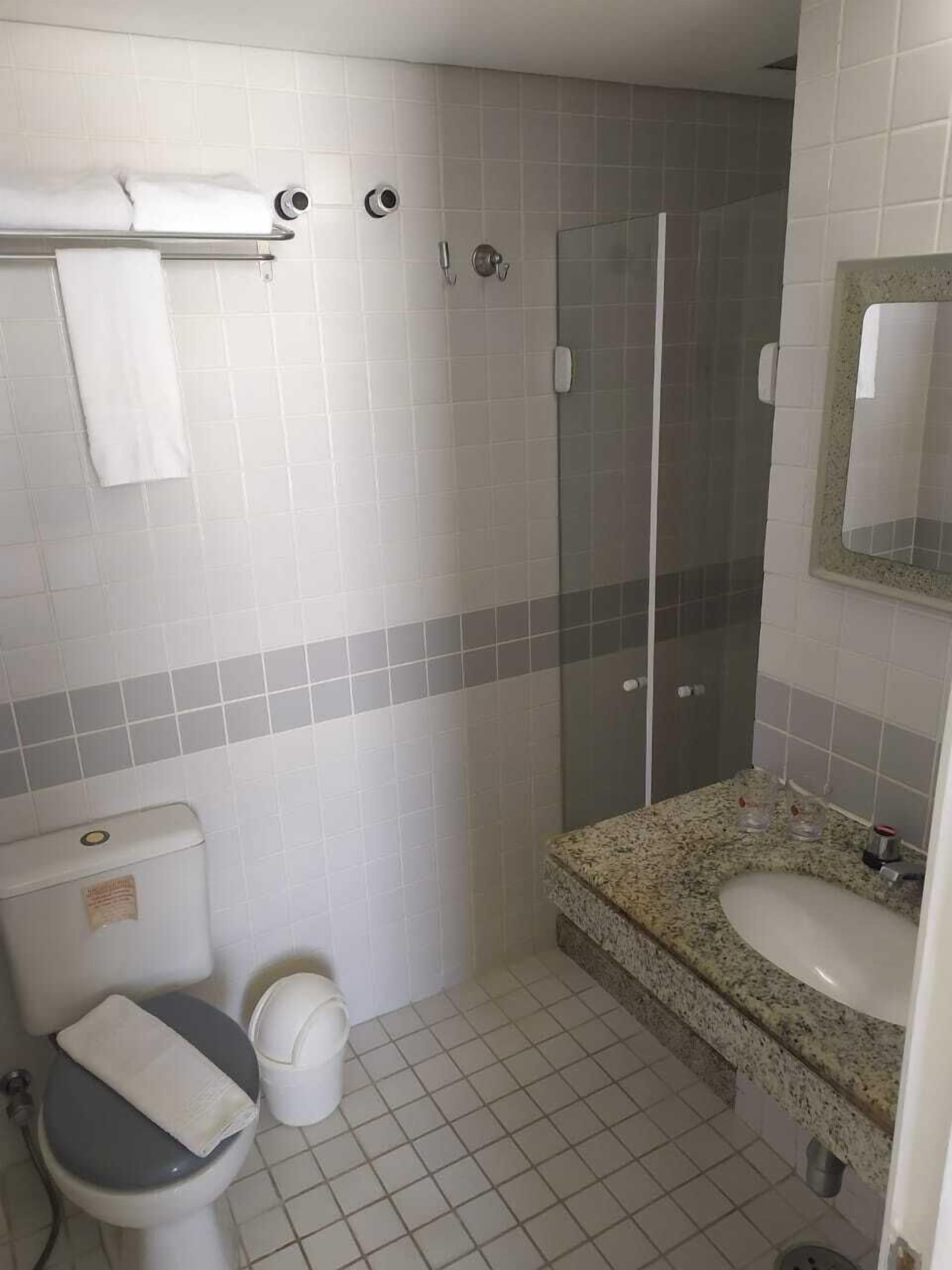 A bathroom with a toilet, sink, and shower.