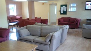 A spacious living area with multiple sofas and a wooden coffee table. - Courtbrack Accommodation - Hostel (Limerick)