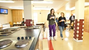 A kitchen area with a large stove, wooden cabinets, and a tiled backsplash. - Courtbrack Accommodation - Hostel (Limerick)