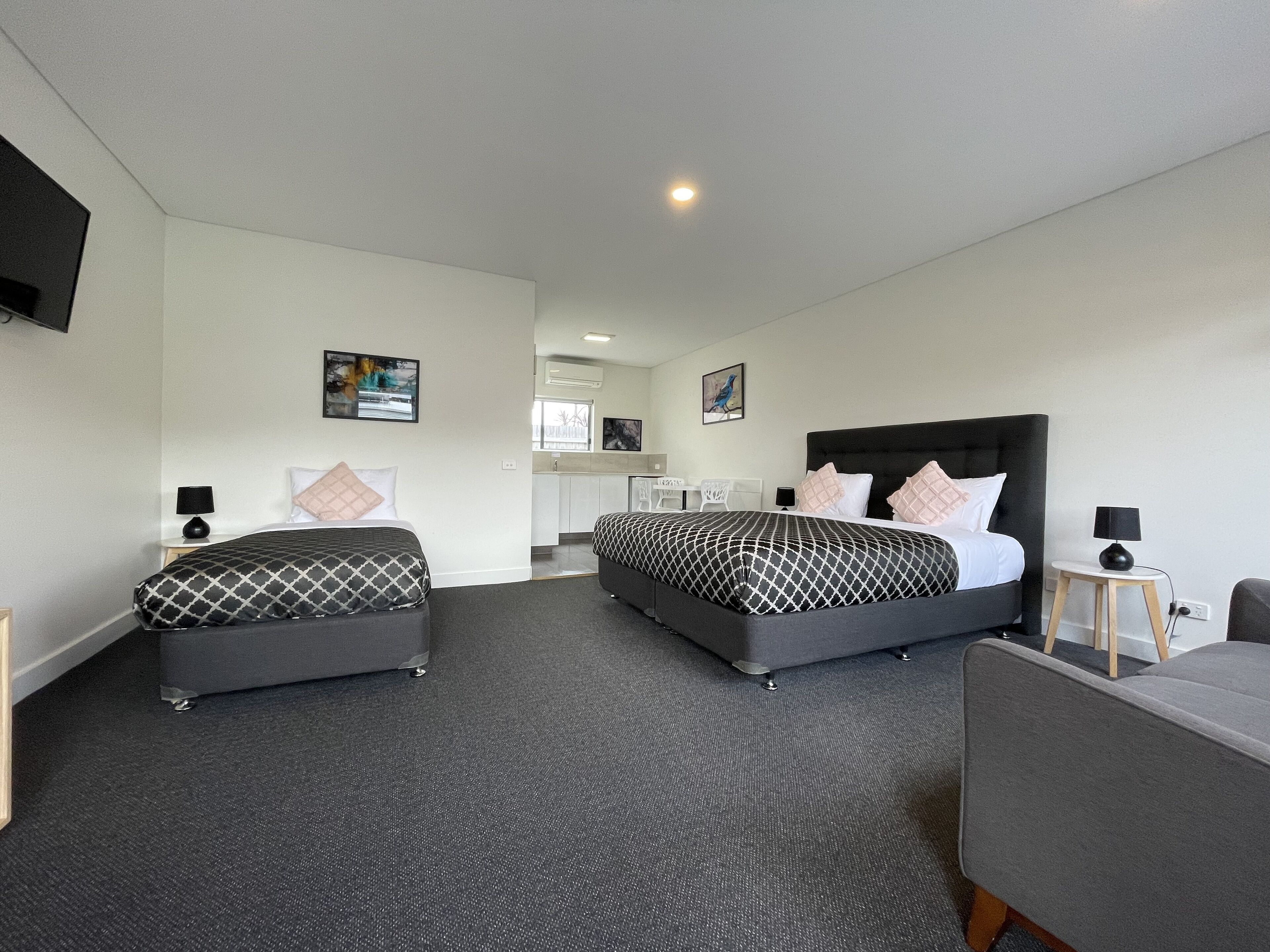 Een hotelkamer met twee bedden, een bureau en een stoel.