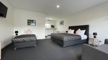 Een hotelkamer met twee bedden, een bureau en een stoel.