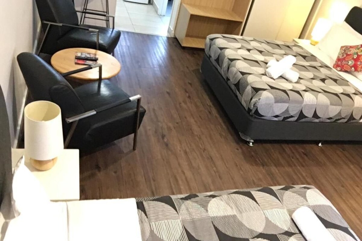 Ein Hotelzimmer mit einem Bett, einer Couch, einem kleinen runden Tisch und einem Sessel.