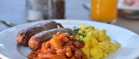 Un plato con salchichas, frijoles y huevos revueltos.