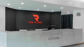 A reception desk with a logo, a clock, and a nameplate.