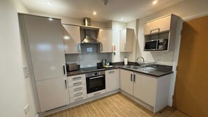 Una cocina moderna con horno empotrado, microondas y electrodomésticos de acero inoxidable.