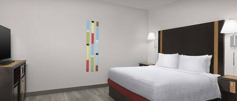 Habitación de hotel con cama, mesitas de noche, televisor y decoración mural colorida.