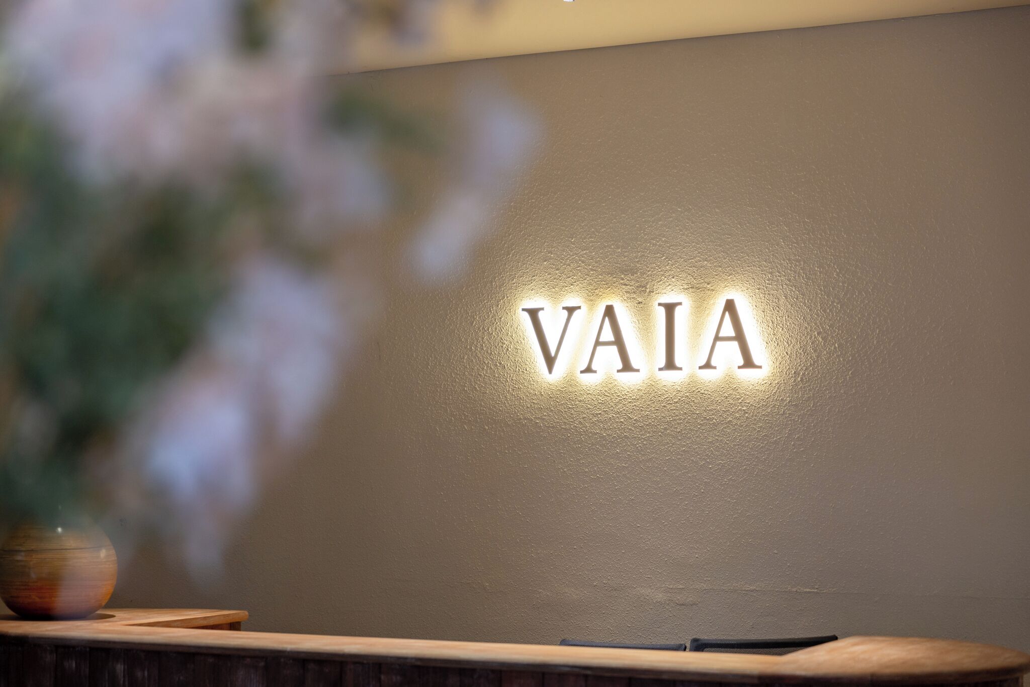 Un comptoir d’accueil avec une enseigne fixée au mur sur laquelle on peut lire « VAIA ».