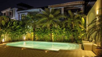 Una piscina al aire libre, sombrillas, sillones reclinables de piscina