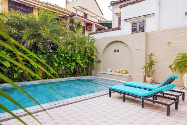 Utomhuspool, parasoller och solstolar