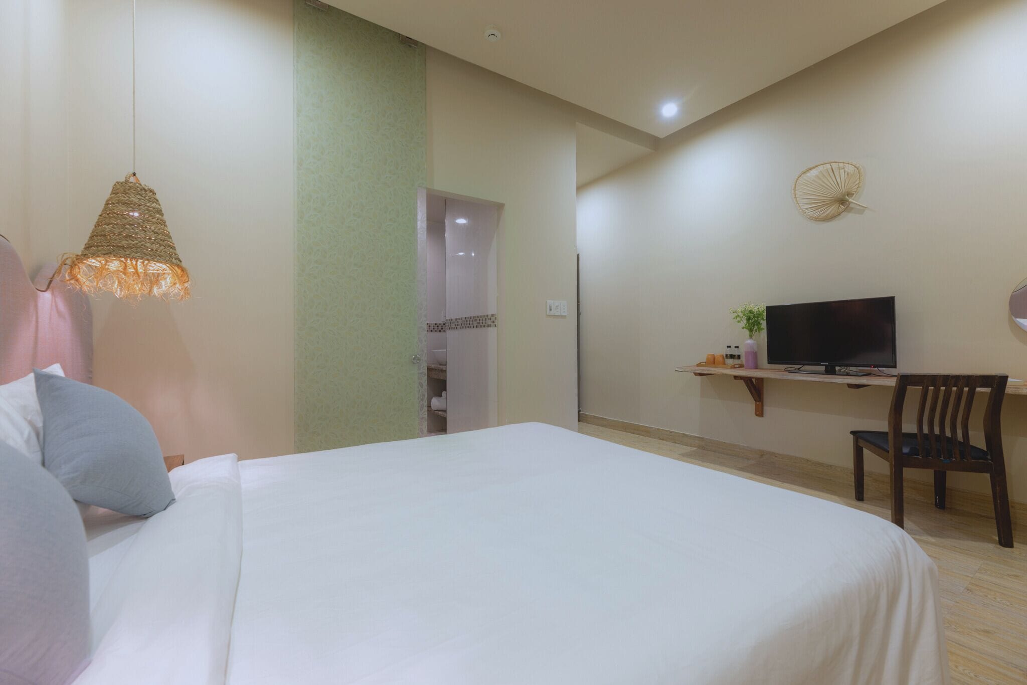A hotel room with a bed, a television, a desk, and a chair.