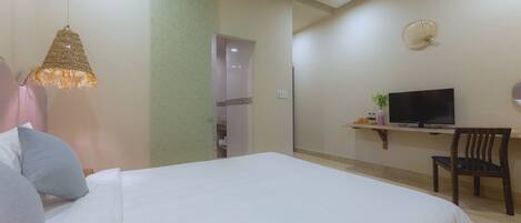 A hotel room with a bed, a television, a desk, and a chair.