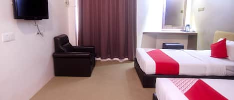 A hotel room with a bed, a chair, a desk, a TV, and a window with curtains.