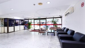 A hotel lobby with a reception desk, seating area, and a view of the street outside. - Hotel O Hua Kuok Inn (Kuching)