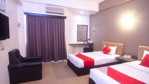 A hotel room with two beds, a desk, a chair, an air conditioning unit, and a television. - Hotel O Hua Kuok Inn (Kuching)