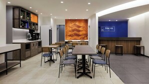 A modern dining area with a long table, chairs, and a counter with a blue sign reading "TOKYO". - Four Points Flex By Sheraton Tokyo Ueno (Tokyo)