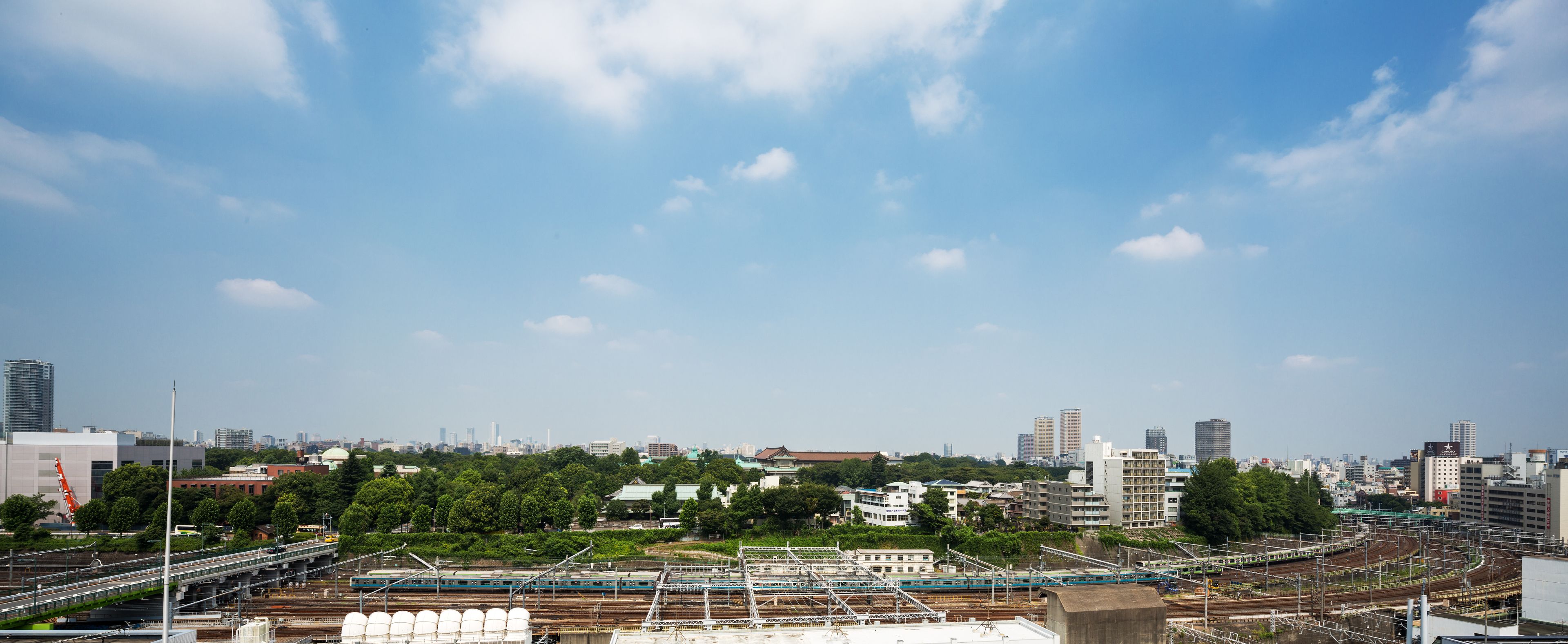 A cityscape with a train station and surrounding buildings.