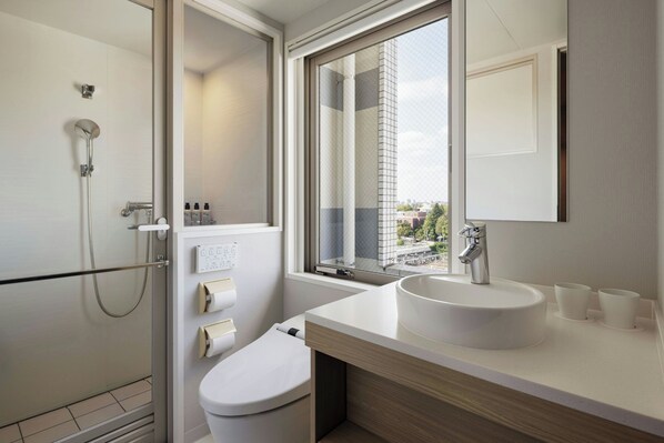 A modern bathroom with a glass shower enclosure, a white sink, and a large window offering a city view. - Four Points Flex By Sheraton Tokyo Ueno (Tokyo)