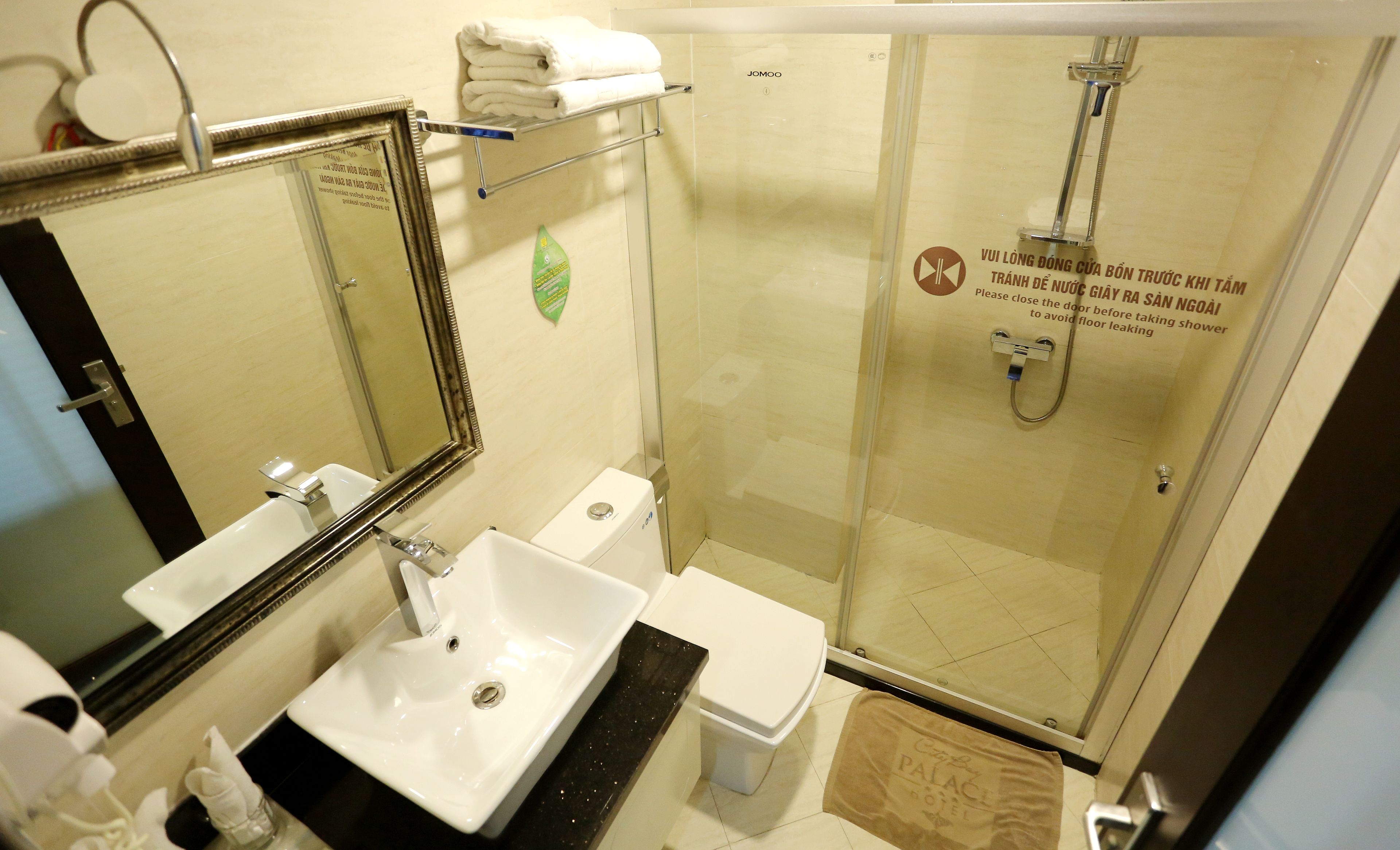 Un baño con lavabo, inodoro y ducha con mampara de vidrio.