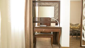 A wooden desk with a mirror, a book, and a lamp.