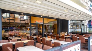 Un restaurante moderno con diversas opciones de asientos, incluyendo cabinas y mesas.