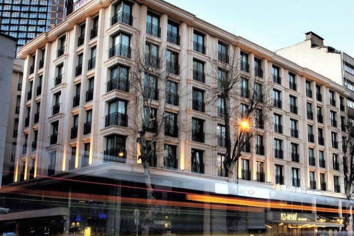 A multi-story hotel with a prominent sign, large windows, and a modern glass entrance.