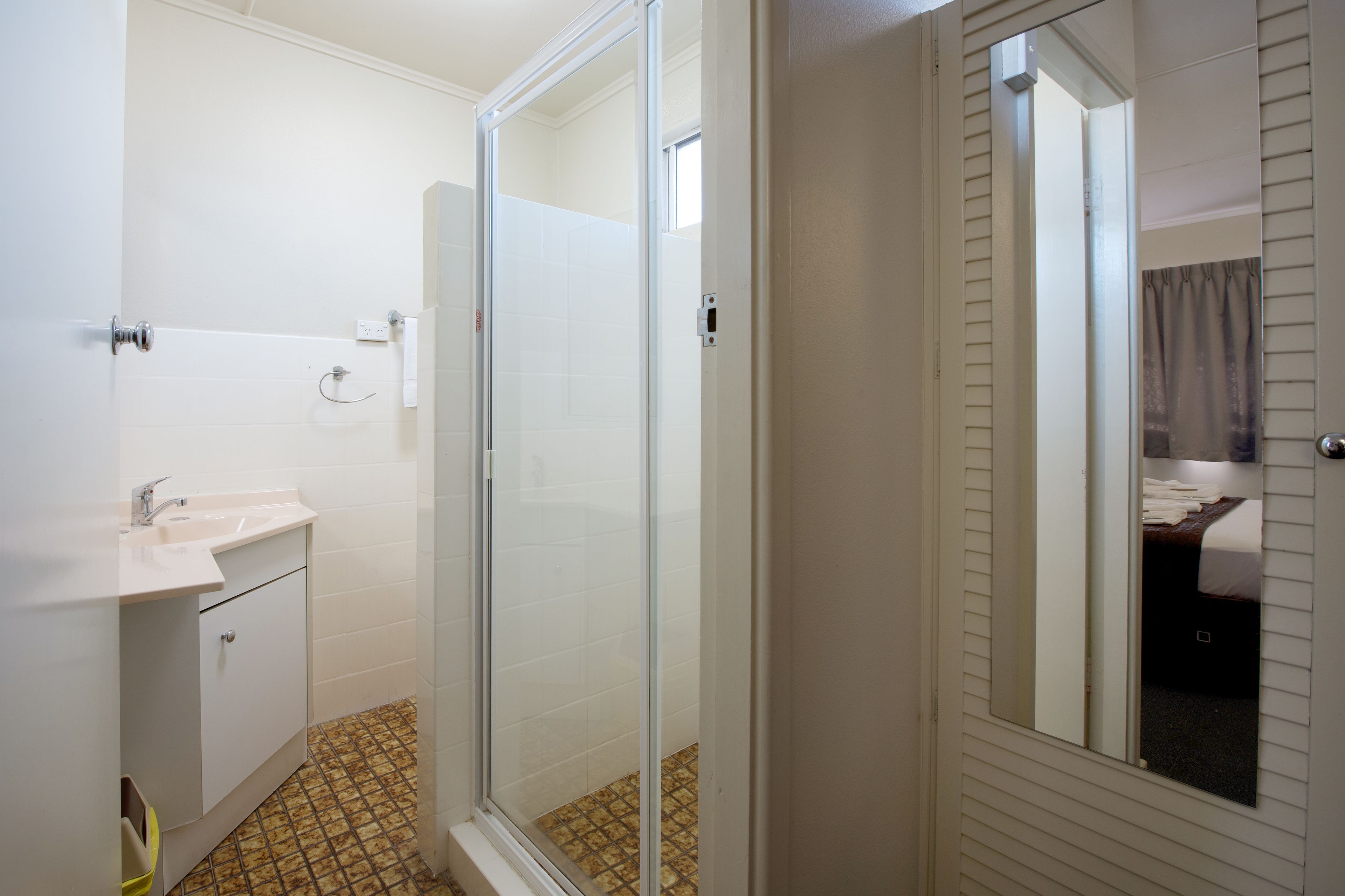 Een hotelbadkamer met douche, wastafel en toilet.