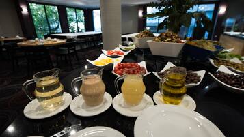 A buffet table with various food items and beverages.