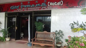 The entrance of GW FURAMA Hotel with a wooden bench and potted plants in front. - GW Furama Apartment (Kuching)