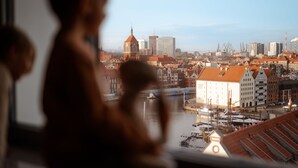 A view of a cityscape with a prominent building with a red roof and a clock tower. - Marina Club Hotel (Gdansk)