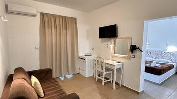 Ein Hotelzimmer mit Sofa, Schreibtisch und einem Bett.