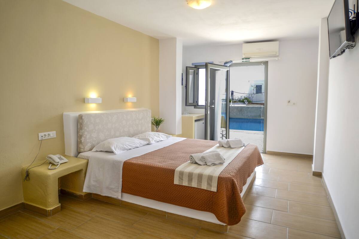 Une chambre d’hôtel avec un lit, une table de chevet et une vue sur un balcon.