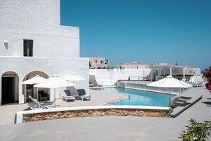 Alberca al aire libre, sombrillas en la alberca y camastros 