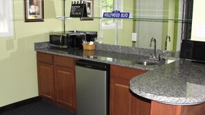 Una cocina con lavavajillas, cafetera y un cartel que dice "Vine St Hollywood Blvd".